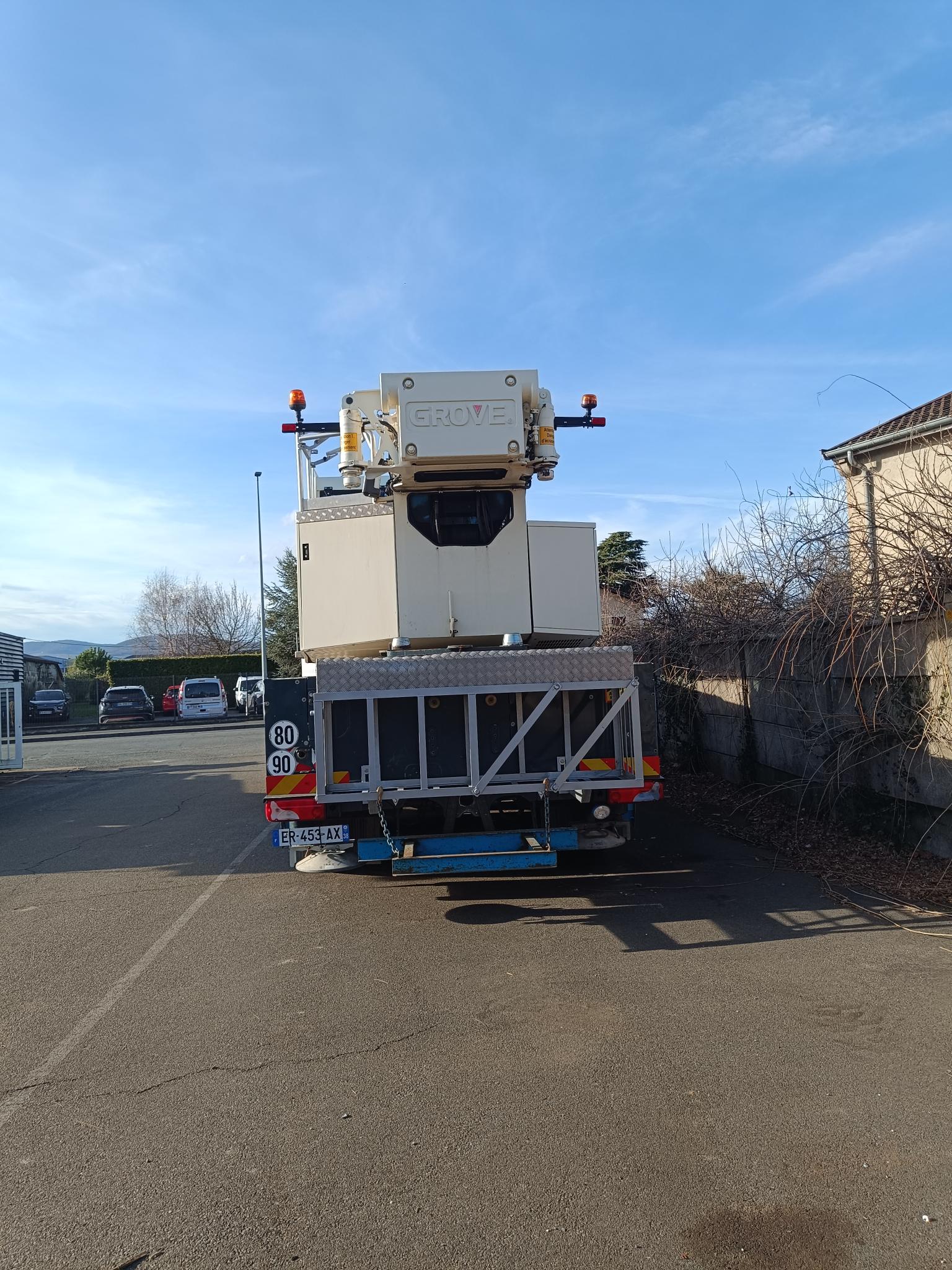 Camion nacelle Grove stationné sur un parking
