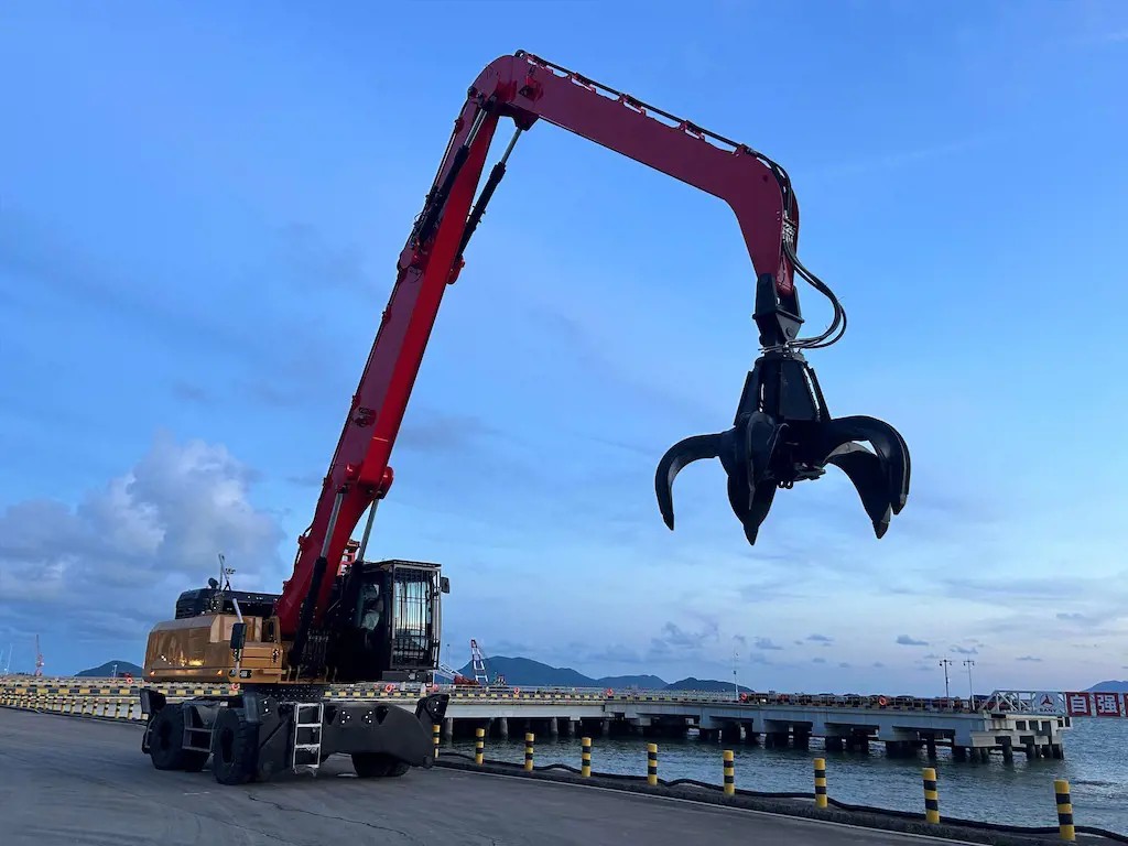 Grue hydraulique rouge sur quai portuaire